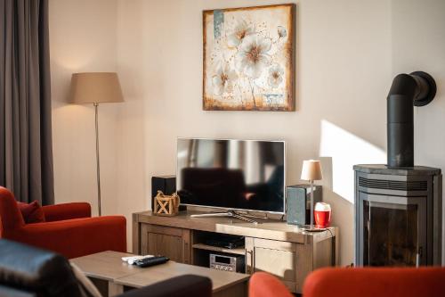 a living room with a tv and a couch and a table at Residence Lipno in Lipno nad Vltavou