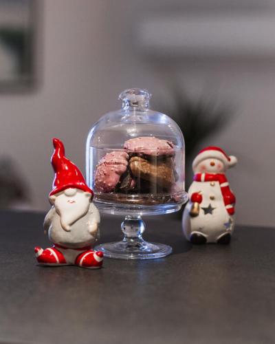 a glass cloche with food in it next to two figurines at Apartmani Lucija in Ludbreg