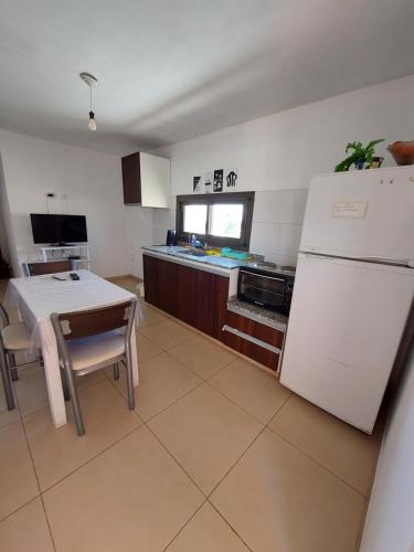 a kitchen with a table and a white refrigerator at Departamento temporario Federal in La Rioja