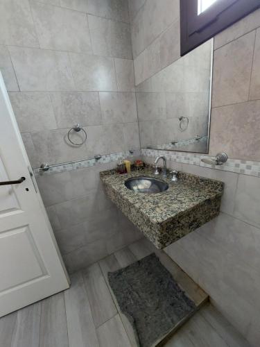 a bathroom with a sink and a mirror at Departamento temporario Federal in La Rioja