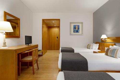 a hotel room with two beds and a desk at TRYP by Wyndham Montijo Parque Hotel in Montijo