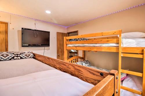 a bedroom with two bunk beds and a flat screen tv at Game Room and Lake Access Albrightsville Home! in Albrightsville