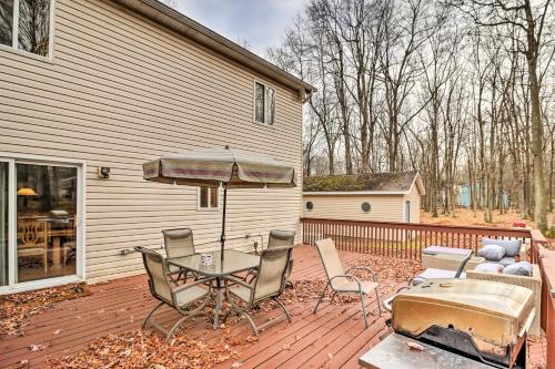 a patio with a table and chairs and an umbrella at Game Room and Lake Access Albrightsville Home! in Albrightsville