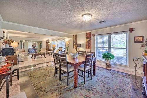 a dining room and living room with a table and chairs at Stunning Rogers Villa with Pond about 7 Mi to Lake in Rogers