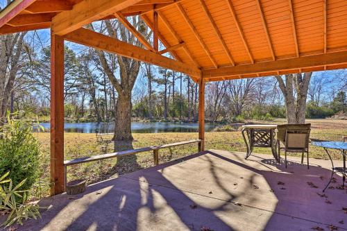 a wooden pergola with a table and a bench on a patio at Stunning Rogers Villa with Pond about 7 Mi to Lake in Rogers