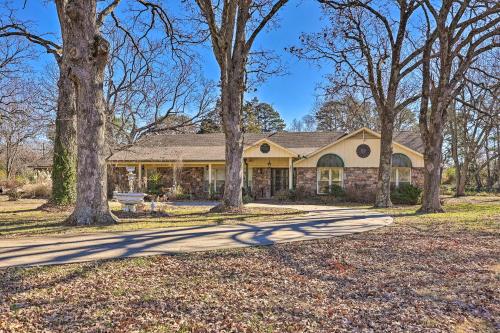 a house with trees in front of it at Stunning Rogers Villa with Pond about 7 Mi to Lake in Rogers