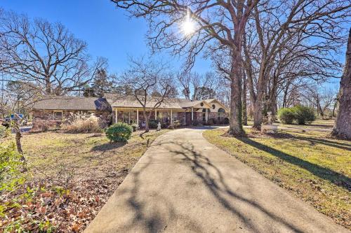 a road leading to a house with trees at Stunning Rogers Villa with Pond about 7 Mi to Lake in Rogers