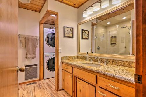 a bathroom with a sink and a washer and dryer at Quiet and Cozy Twain Harte Cabin with Forest View in Twain Harte