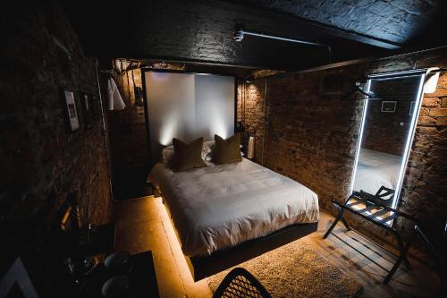a bedroom with a bed in a brick wall at Impossible Motel in York