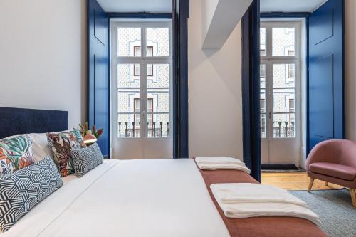 1 Schlafzimmer mit einem großen weißen Bett und 2 Fenstern in der Unterkunft Succeed Terreiro do Paço Suites in Lissabon