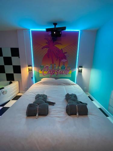 a bedroom with a bed with a neon sign on it at Capsule Miami Vice - Jacuzzi - Billard - Ecran cinéma & Netflix - Ping-Pong - Nintendo & Jeux- in Liévin
