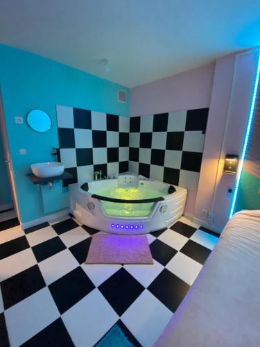 uma casa de banho com uma banheira e um lavatório em Capsule Miami Vice - Jacuzzi - Billard - Ecran cinéma & Netflix - Ping-Pong - Nintendo & Jeux- em Liévin