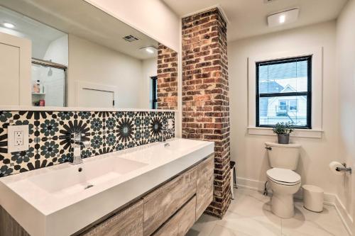 a bathroom with a sink and a brick wall at Grand Long Branch Home 1 Block to Beach! in Long Branch