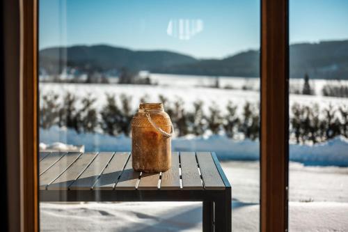 a jar sitting on a table in front of a window at Residence Lipno in Lipno nad Vltavou