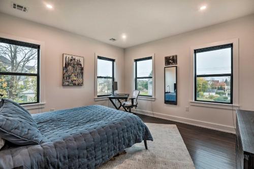 a bedroom with windows and a bed and a desk at Grand Long Branch Home 1 Block to Beach! in Long Branch