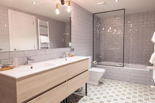 a bathroom with a sink and a tub and a toilet at Hotel Cims de Camprodon in Camprodon