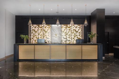 a lobby with a reception desk with lights at Eurostars Gran Madrid in Alcobendas