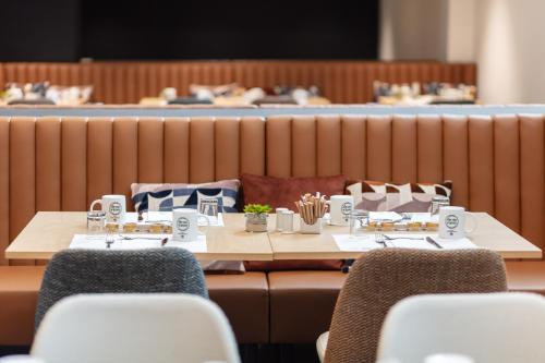 two tables and chairs in a dining room with at Eurostars Gran Madrid in Alcobendas