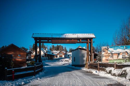 a gate to a village in the snow at Residence Lipno in Lipno nad Vltavou