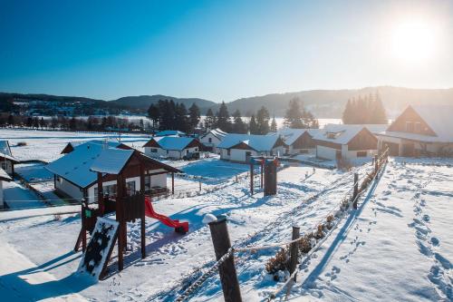 a playground covered in snow next to houses at Residence Lipno in Lipno nad Vltavou