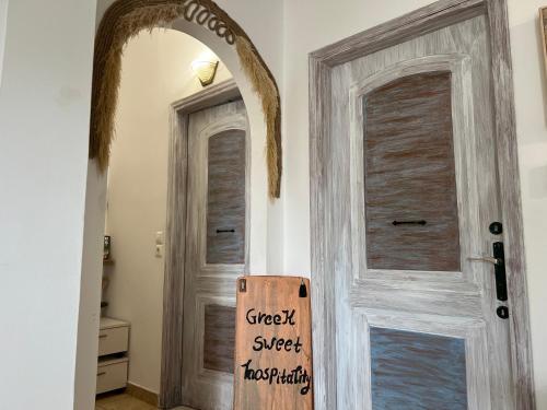 a door with a sign that reads great sweet hospitality at ALONI G&A Archaggelos in Archangelos