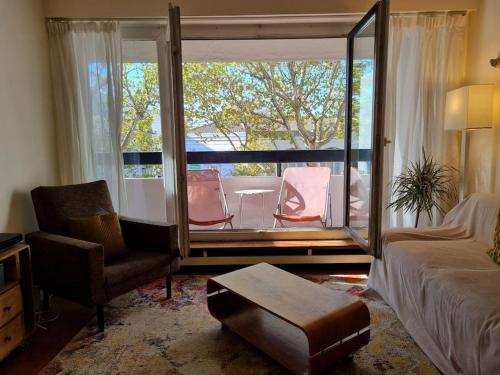 a bedroom with a bed and a balcony with chairs at HEY PARIS Entire apartment in Paris