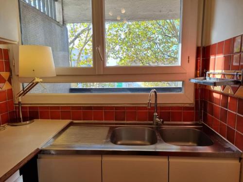 kuchnia ze zlewem i oknem w obiekcie HEY PARIS Entire apartment w Paryżu