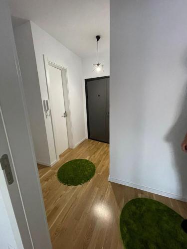 a room with white walls and green rugs at Lovely apartment in Peja Citycenter in Peje