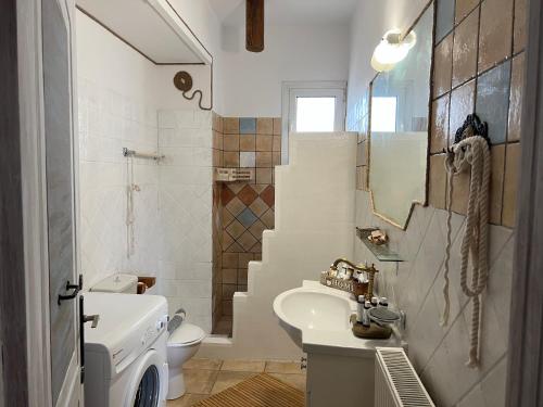 bagno bianco con lavandino e servizi igienici di ALONI G&A Archaggelos a Archangelos