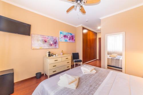 a bedroom with a white bed and a dresser at Boa Vida Alojamentos in Vagos
