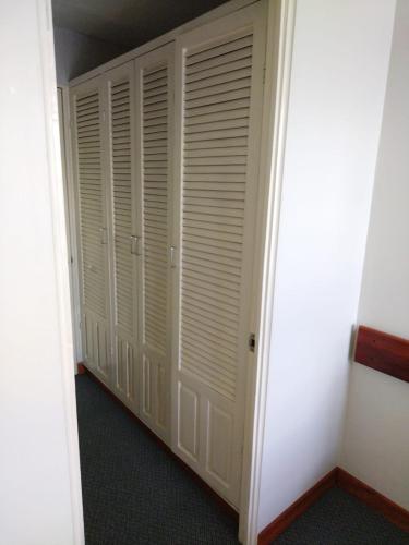 a closet with white closet doors in a room at Apartotel Tairona in San Pedro