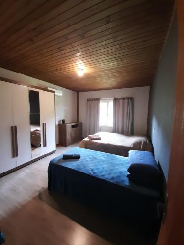 a bedroom with two beds and a wooden ceiling at Refúgio Altos do Campestre - TURISMO RURAL in Urubici