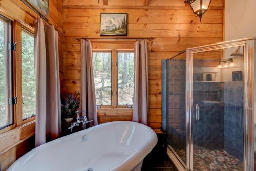 uma casa de banho com uma banheira e um chuveiro em vidro. em Boles Lodge em Boone