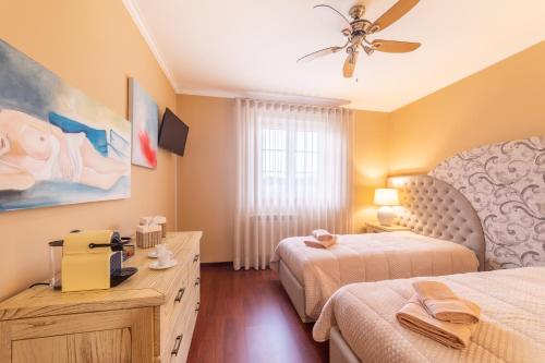 a bedroom with two beds and a ceiling fan at Boa Vida Alojamentos in Vagos