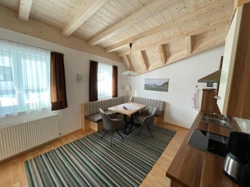 a living room with a table and chairs in a room at Appartement Thurnbach in Aschau