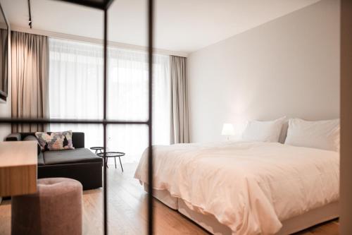 a hotel room with a bed and a chair at Design Hotel Tyrol in Rablà
