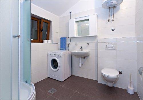 een badkamer met een wasmachine en een wastafel bij Villa Mirta in Široke