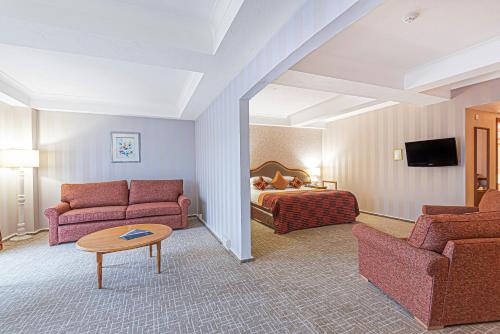 a hotel room with a bed and a couch and a table at Coppid Beech in Bracknell