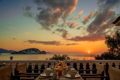 a table with a view of the ocean at sunset at Marathia Cottages Zakynthos Greece in Marathias