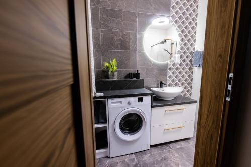 een badkamer met een wasmachine en een wastafel bij Hello Kielce in Kielce