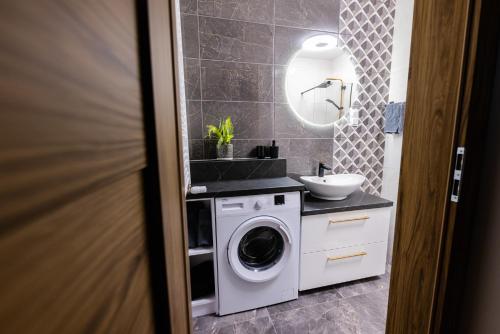 a bathroom with a washing machine and a sink at Hello Kielce in Kielce
