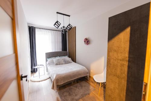 um pequeno quarto com uma cama e uma janela em Hello Kielce em Kielce