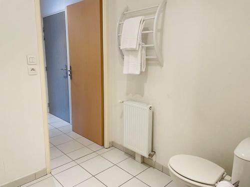 ein Bad mit WC und Handtüchern an der Wand in der Unterkunft Majestic in Besançon