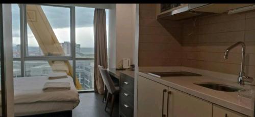 eine Küche mit einem Waschbecken und einem großen Fenster in der Unterkunft SBK HOTEL in Istanbul