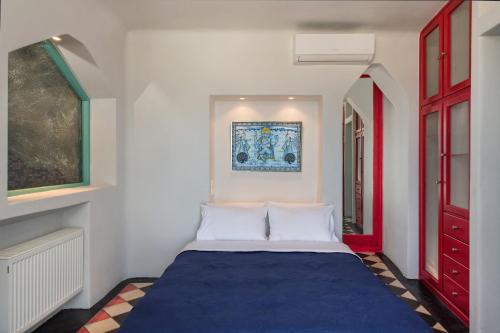 a bedroom with a blue bed in a room at Fira center houses in Fira