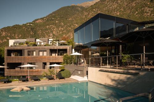a hotel with a swimming pool and a mountain at Design Hotel Tyrol in Rablà