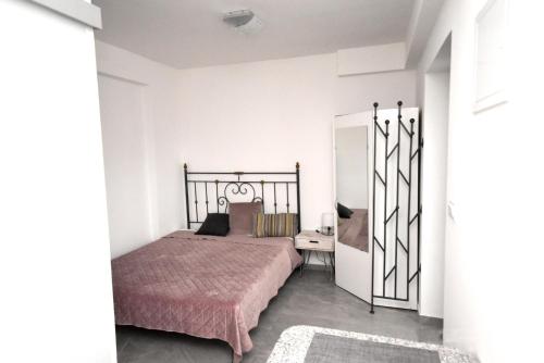 sypialnia z łóżkiem i białą ścianą w obiekcie apartmaji LEJARDIN w mieście Škofljica