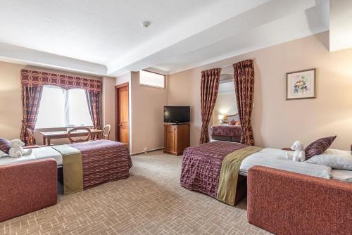 a hotel room with two beds and a television at Coppid Beech in Bracknell