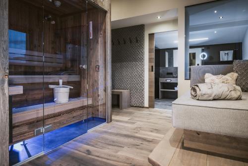 a bedroom with a bed and a glass wall at Margarethenstein Boutique Hotel in Kaprun