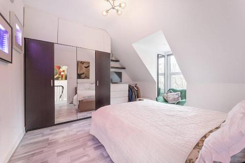a bedroom with a bed and a large mirror at Stylish, modern, Kensington apartment in London